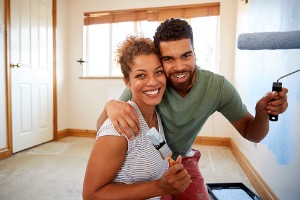 Couple painting walls in room